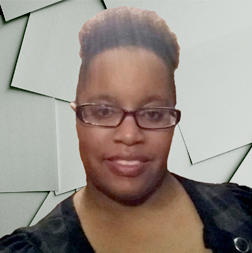 A person with short, styled hair and glasses is smiling at the camera, wearing a black top, with a background of overlapping gray rectangles.